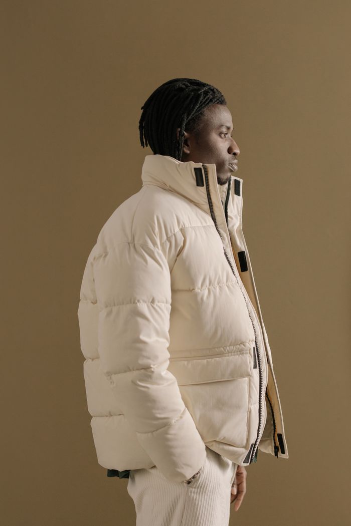 Profile portrait of a stylish man in a winter coat, beige background